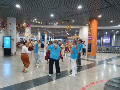 Travellers dancing at the airport with local community.