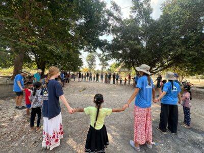 School Children and student expedition team playing games in Cambodia.