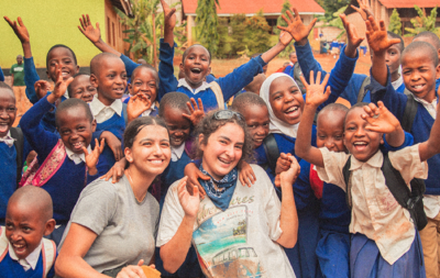 Travellers waving with local school children in Tanzania.