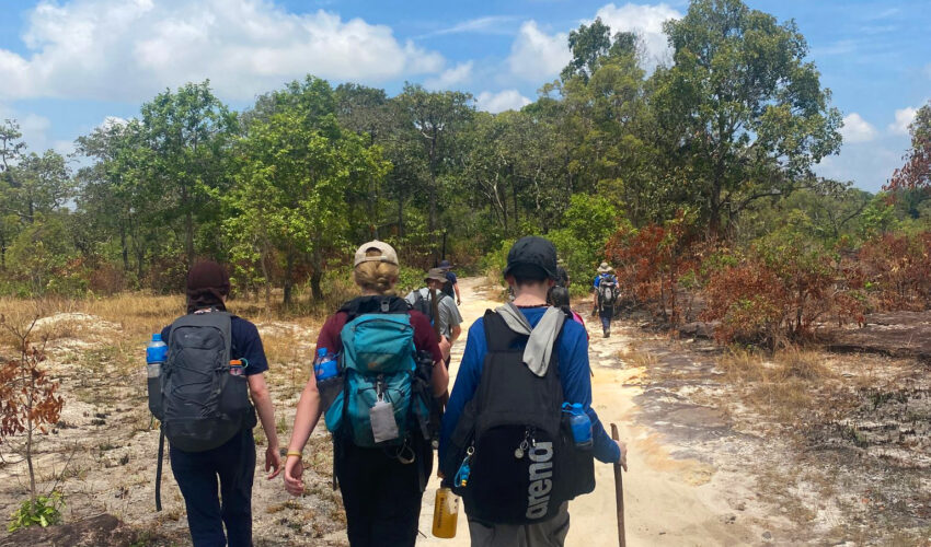 A group of travellers walking on a path in Cambodia