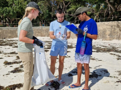 Three students from the UAE on an expedition in Africa with Camps International, conducting a beach clean up.