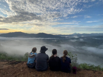 a group of travellers looking at the vista in bongkud hill, borneo