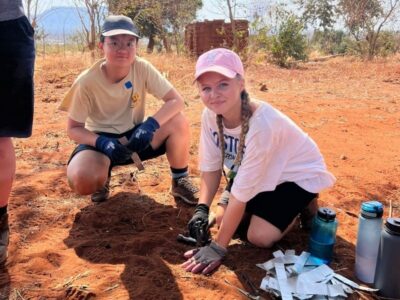 Two young students on a Camps International expedition in Tsavo, Kenya, building an elephant deterrent fence for the local community.