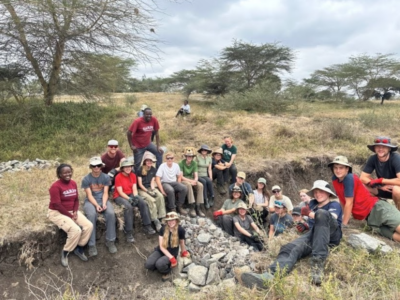 Group of students on a Camps International expedition to Kenya all sitting together after having completed some project work at The Wildlife Foundation
