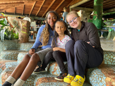 Two teenagers and a young girl sitting on mosaic steps
