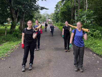 students walking along a road carrying conservation equipment