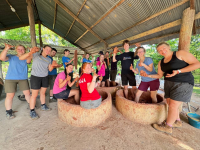 Student travellers building clay pots in Cambodia