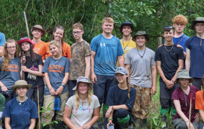 Group of travellers and locals posing together in the jungle in Borneo