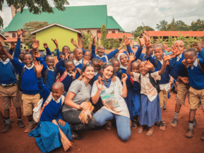 Student travellers posing for a photo with local children from Tanzania