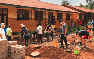 student travellers doing project work and building a path in a local school in Tanzania