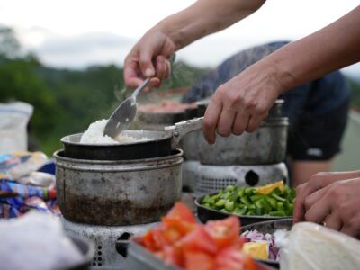 rice and veggies being cooked in a camp