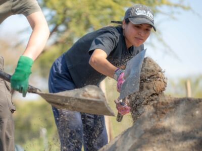 a girl traveller doing project work holding a shovel