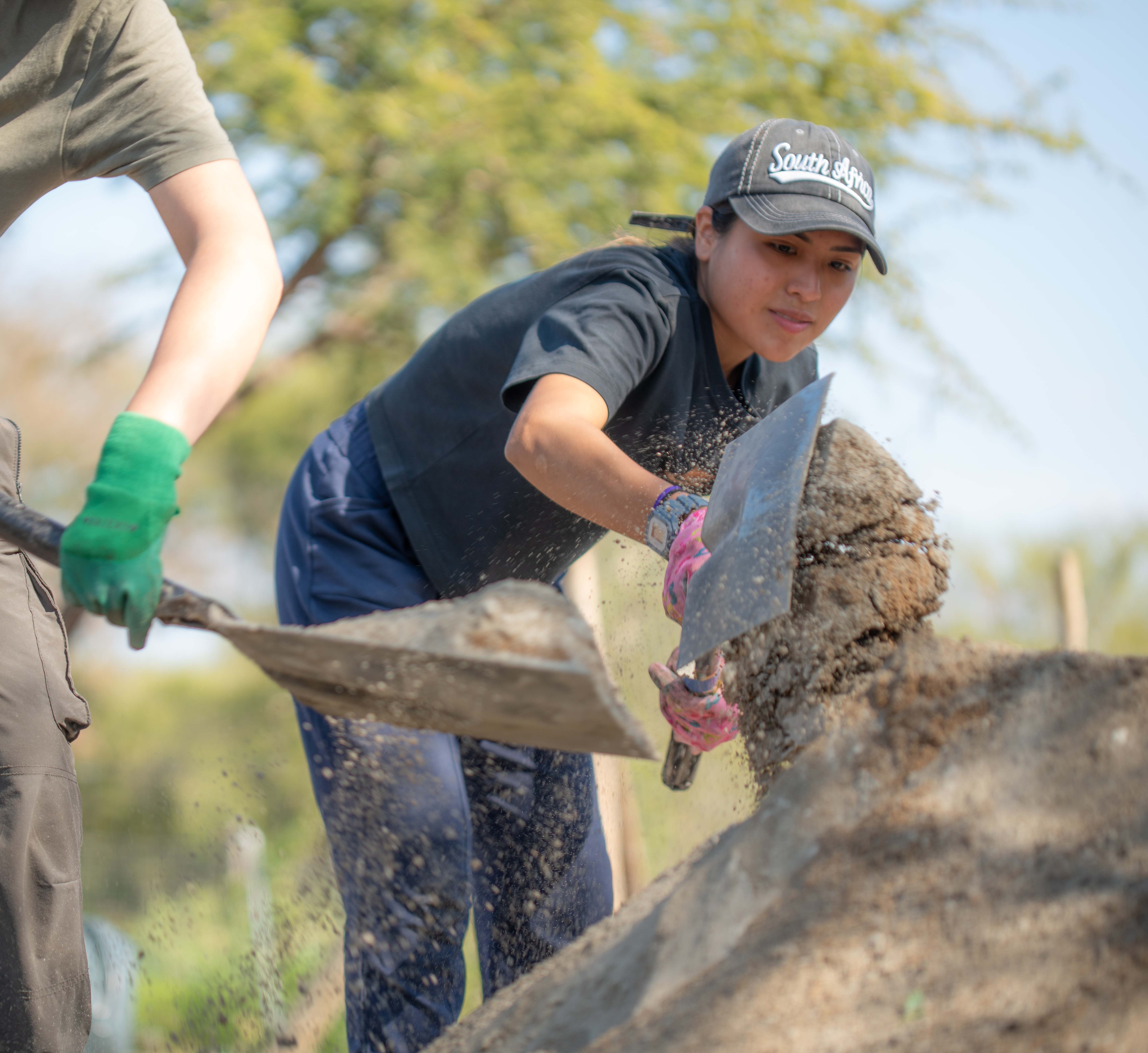 a girl traveller doing project work holding a shovel