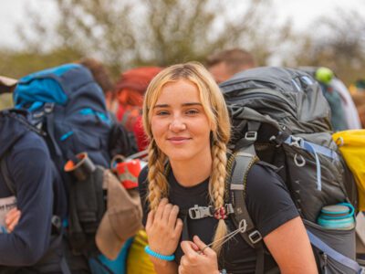 blond student traveller with a backpack smiling at the camera