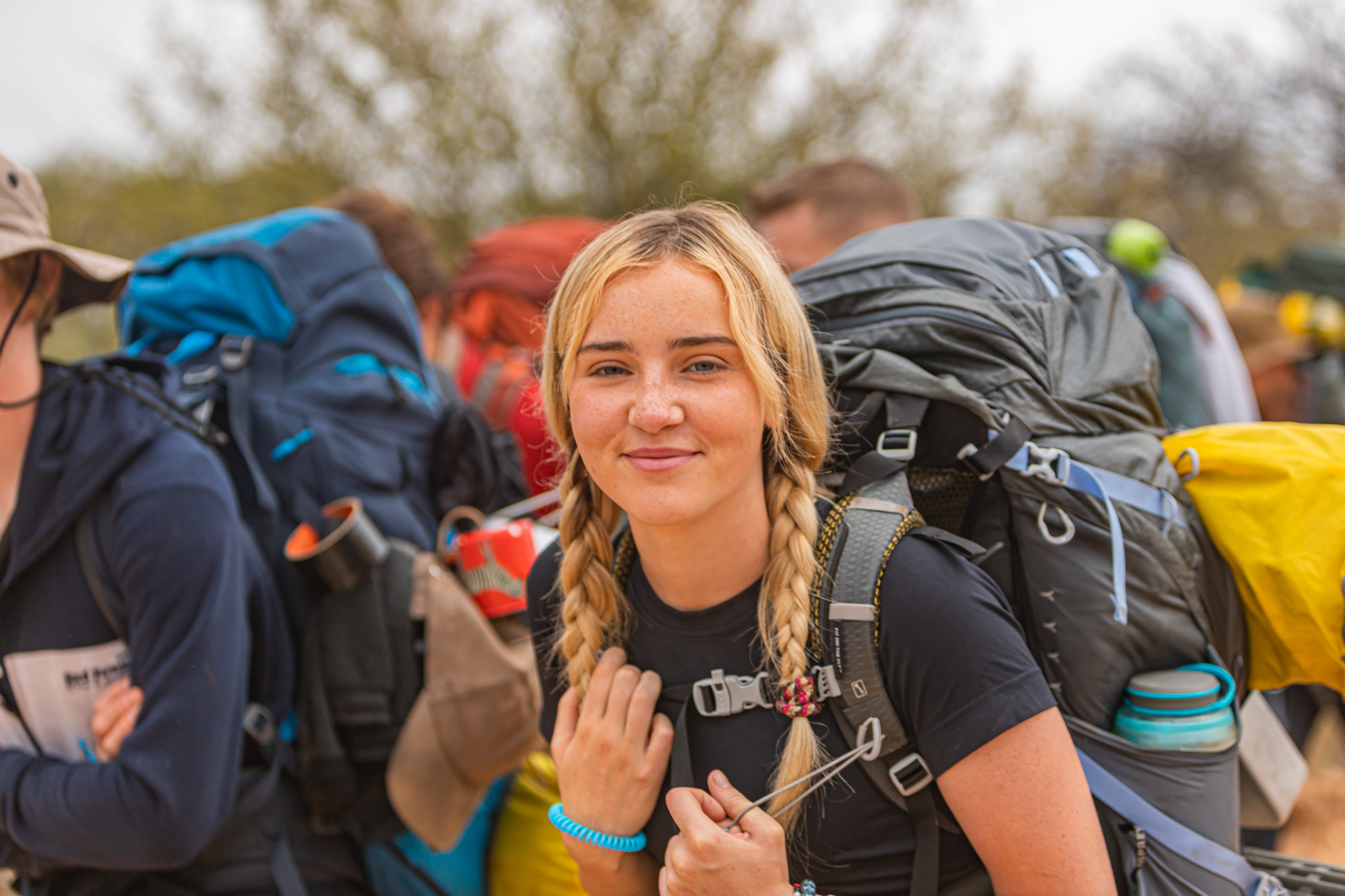 blond student traveller with a backpack smiling at the camera