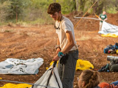 a boy traveller setting up a tent