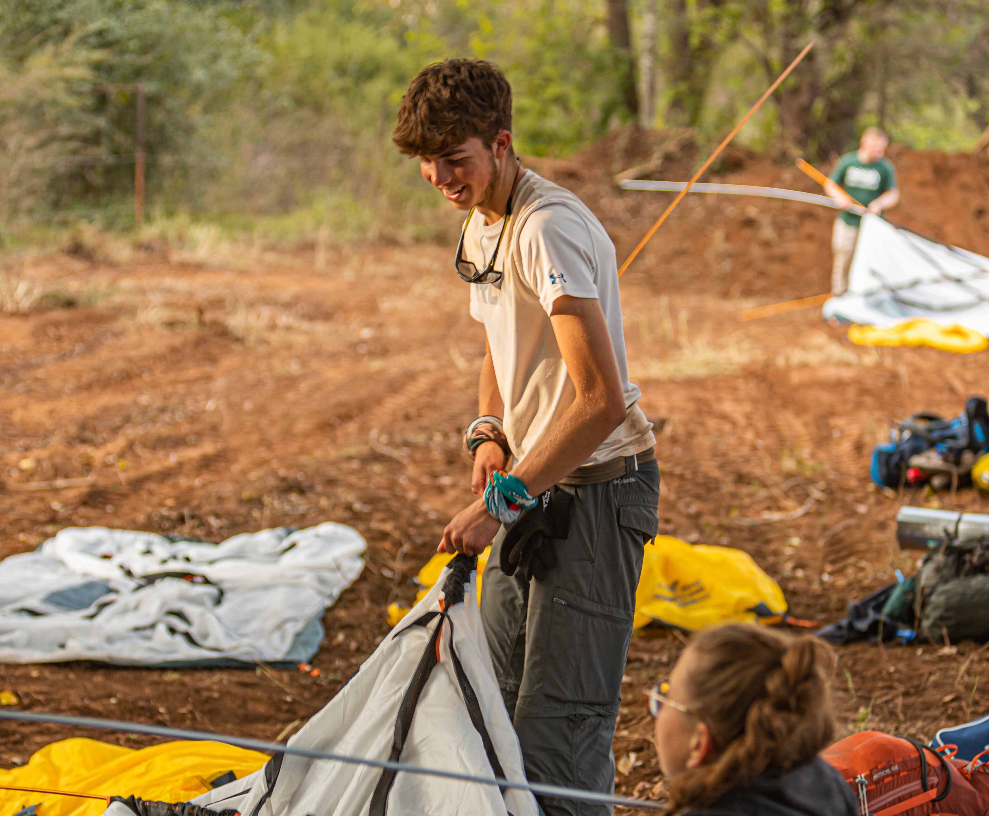 a boy traveller setting up a tent