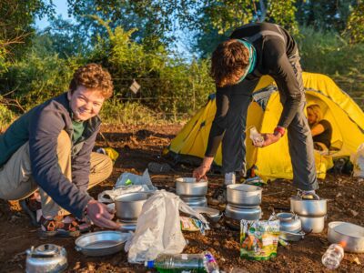 Two boys travellers preparing to cook at a campsite