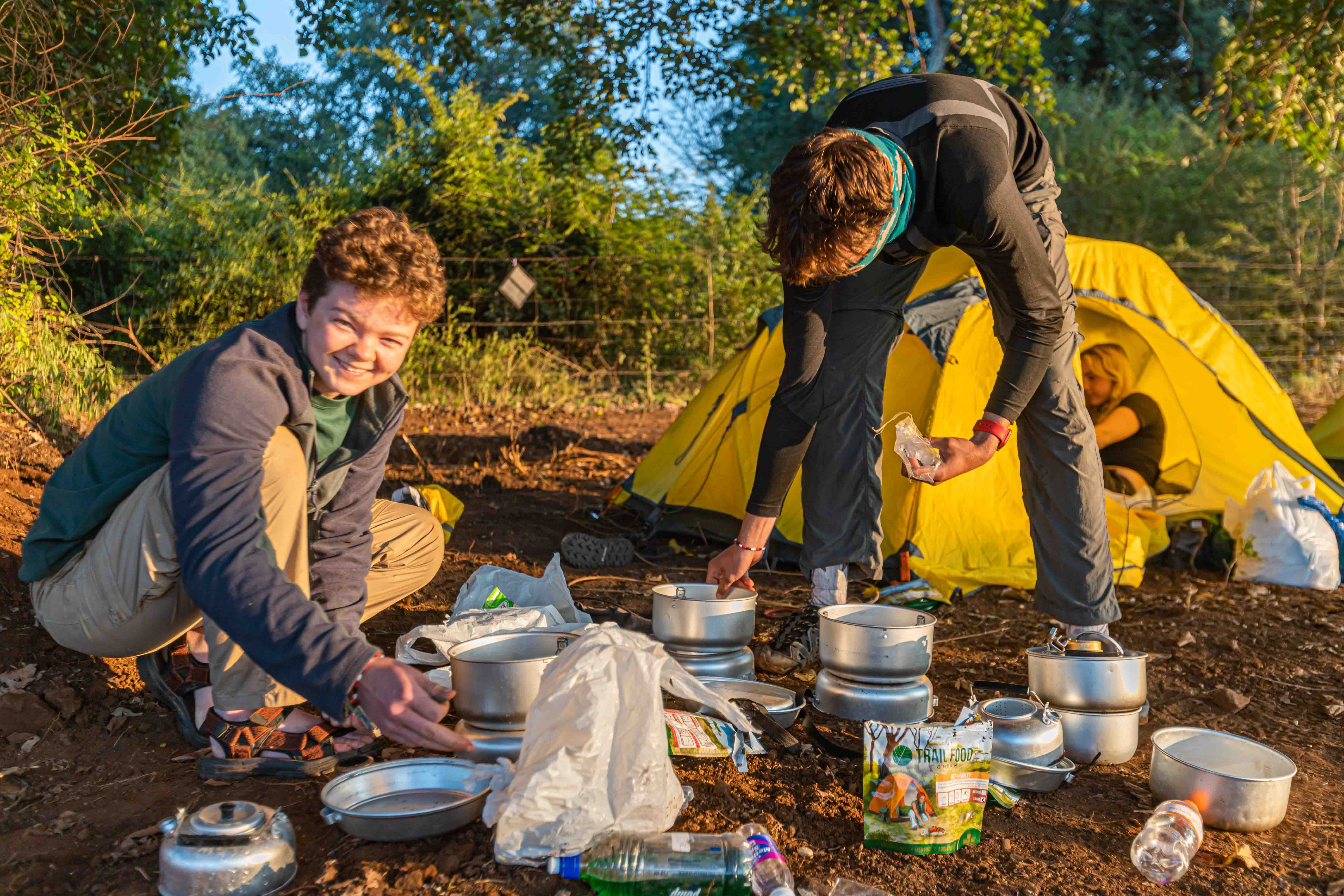 Two boys travellers preparing to cook at a campsite