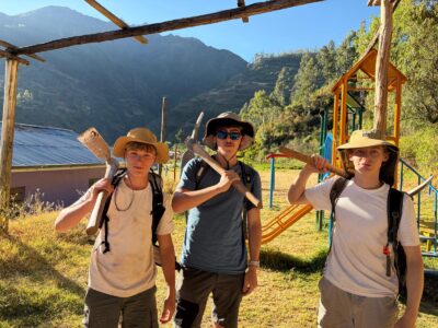 three boys holding project work tools in Peru