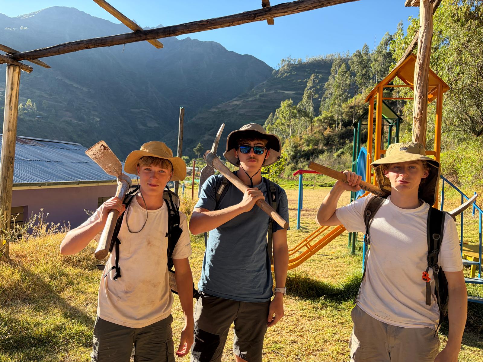 three boys holding project work tools in Peru