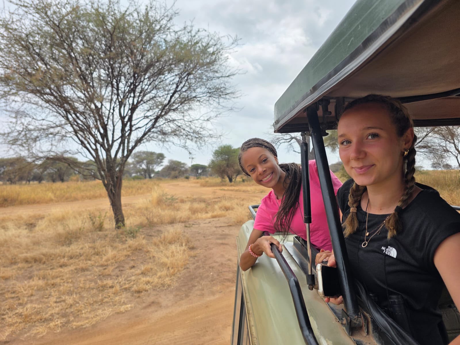 two girls smiling in a safari jeep in Tanzania